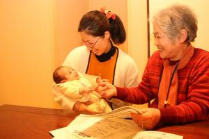 お母さんとおばあちゃんが乳児をあやしている様子