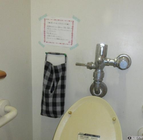 トイレの個室に生理用ナプキンの入った袋がかかっている写真です。