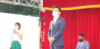 ステージであいさつする市長　うしろに司会者