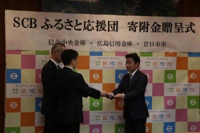 寄付贈呈式で目録を受け取る市長