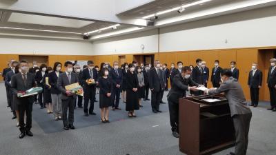 整列する退職者と中央で書類を渡す市長