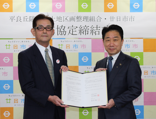 協定書を手にする竹内理事長と松本市長