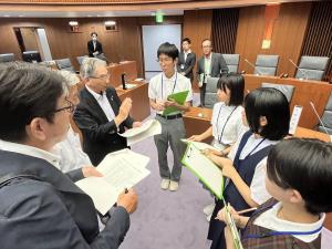 子ども議員が市議会議員からアドバイスを受ける様子