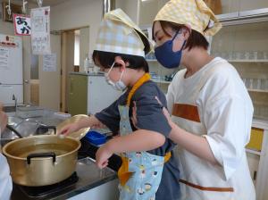 よもぎだんごをお湯の沸いた鍋の中へ入れる