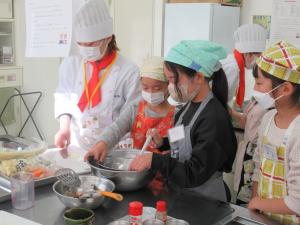 学生に教えてもらいながら料理している様子