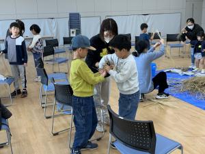 わらを兄弟で結んでいる様子