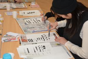 参加者（親子）が筆文字を練習している様子